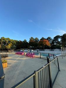 een groep roze stoelen op een parkeerplaats bij Chez "Greg et ilhem" in Lège-Cap-Ferret