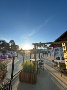 een terras met tafels en stoelen en uitzicht op het water bij Chez "Greg et ilhem" in Lège-Cap-Ferret
