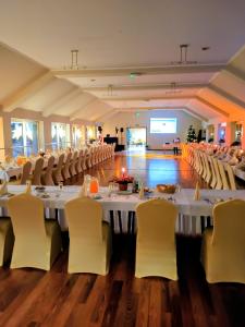 ein großer Bankettsaal mit weißen Tischen und Stühlen in der Unterkunft Dom Wczasowy GLOBUS in Ustroń + 20 Fotos