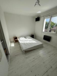 een witte slaapkamer met een bed en een raam bij Villa Zena in Saint-Bonnet-de-Mure