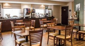 a restaurant with tables and chairs and a kitchen at Sleep Inn Johnstown - Richland Town Center in Geistown