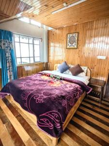 a large bed in a room with wooden walls at Foggy Hill's Darjeeling in Darjeeling