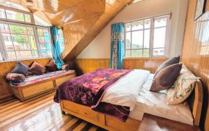 a bedroom with a bed and a bench in a room at Foggy Hill's Darjeeling in Darjeeling +9 photos