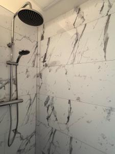 een douche met een witte marmeren muur bij Studios 4 nations in Épinal