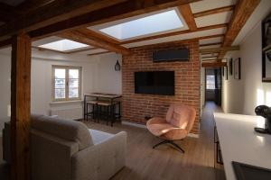 ein Wohnzimmer mit einer Couch und einer Backsteinwand in der Unterkunft Rosette Residence LOFT Jacuzzi in Toruń