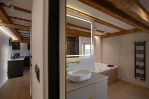 ein Badezimmer mit einem weißen Waschbecken und einer Badewanne in der Unterkunft Rosette Residence LOFT Jacuzzi in Toruń + 24 Fotos