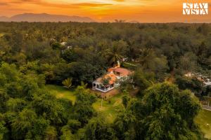 een luchtfoto van een huis in het bos bij StayVista at Jims Farmstay with Pool, Pet-friendly in Halgūr