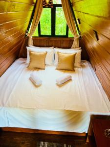 a bed in a room with two books on it at Eco Cabana Bellwood Kandy in Kandy