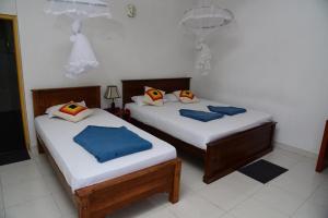 two beds in a room withthritisthritislictslictslictslicts at Super View Home Stay in Ella