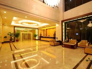 eine Lobby mit zwei Personen, die auf Sofas in einem Gebäude sitzen in der Unterkunft Silver Art Hotel in Zhuhai