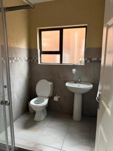 a bathroom with a toilet and a sink at Cozzy home in Polokwane +12 photos