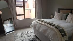 a bedroom with a large bed and a window at Cozzy home in Polokwane