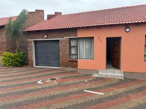 a red brick house with a garage at Cozzy home in Polokwane