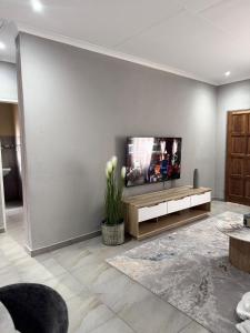 a living room with a flat screen tv on a wall at Cozzy home in Polokwane