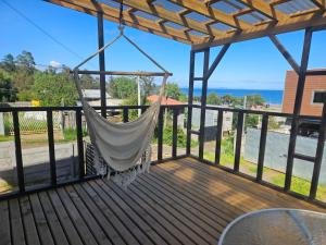 a hammock on a deck with a view of the ocean at Loft playaBlanca in Coronel