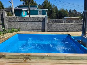 a blue hot tub in a backyard with a house at Loft playaBlanca in Coronel