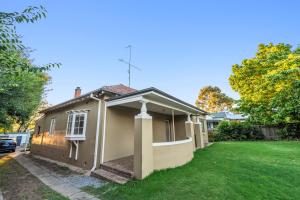 a small house with a green lawn in front of it at Cottage on Carthage in Tamworth