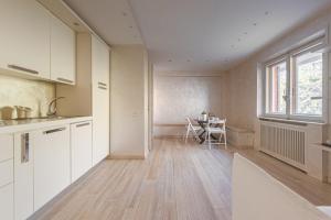 une cuisine avec des armoires blanches, une table et une fenêtre dans l'établissement La Casina, à Terminillo