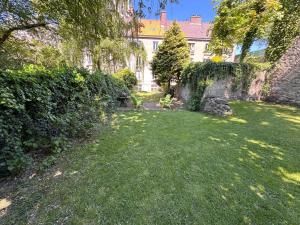 a yard with green grass and a building at Au Beau Duplex de la Basilique in Boulogne-sur-Mer
