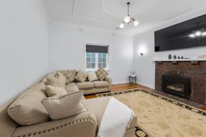 a living room with a couch and a fireplace at Cottage on Carthage in Tamworth