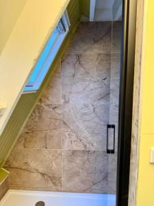 un bagno con una scala con una porta doccia in vetro di Boshuisje Rekem - Nirvana a Lanaken