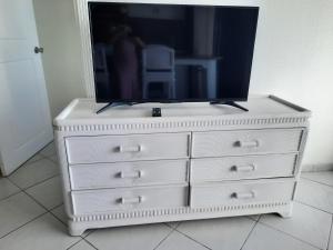 un comò con una tv sopra di Appartement 1 chambre Sapphire Beach a Cupecoy