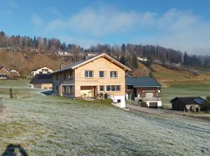 a house on a hill with a grass field at Ferienwohnung Flatz in Egg