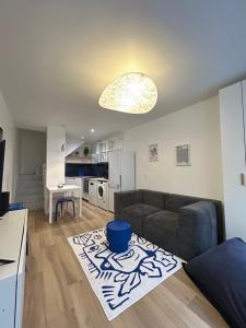 a living room with a couch and a kitchen at Maison et chambre privée - Bordeaux in Bordeaux