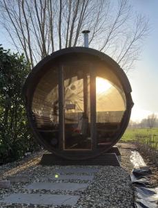 una casa rotonda con una finestra sulla ghiaia di De Hombrake, Bed & Breakfast a Wilp