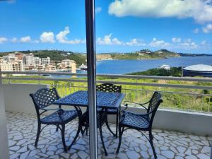 un tavolo e sedie su un balcone con vista sull'acqua di Appartement 1 chambre Sapphire Beach a Cupecoy