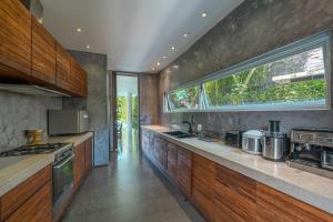 a large kitchen with wooden cabinets and a window at Villa Ashoka Canggu in Canggu