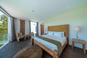 a bedroom with a large bed and a balcony at Villa Ashoka Canggu in Canggu +71 photos