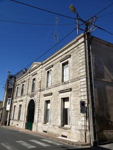 een oud bakstenen gebouw aan de kant van een straat bij Atypique Vendee in Luçon