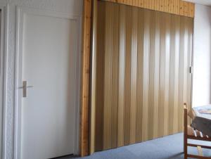 a bedroom with a closet with a sliding door at Le Mont Charvin in La Toussuire