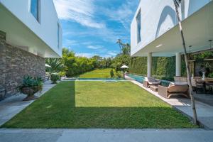 a backyard with a lawn and a swimming pool at Villa Ashoka Canggu in Canggu