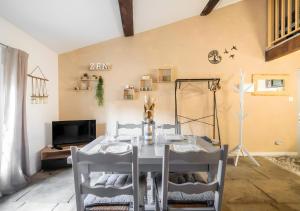 una sala da pranzo con tavolo e sedie bianchi di Cocoon Cosy Coeur de Beaucaire - 4 a Beaucaire