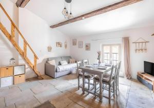 un soggiorno con tavolo, sedie e divano di Cocoon Cosy Coeur de Beaucaire - 4 a Beaucaire