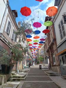a bunch of umbrellas hanging over a street at Duplex charmant centre Joigny - 1 in Joigny