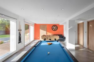 a pool table in a living room with an orange wall at Gîte Perce Neige, Spa, Sauna in Gerbépal