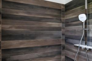 a bathroom with wooden walls and a shower at Gîte Perce Neige, Spa, Sauna in Gerbépal