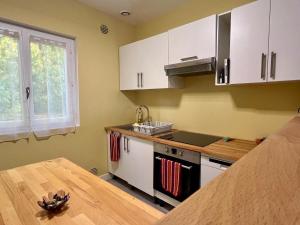 a kitchen with white cabinets and a wooden table at Maison David in Le Buis +8 photos