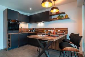 eine Küche mit einem Holztisch und einigen Stühlen in der Unterkunft La Proue - Appartement vue mer in Concarneau + 7 Fotos