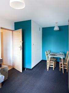 ein Raum mit einem Tisch und Stühlen und einer blauen Wand in der Unterkunft Niron Marina Szalonego Greka in Borne Sulinowo