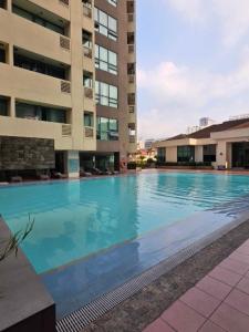 a large swimming pool in front of a building at Robinsons Place Residences Tower 1 in Sampong