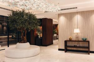 a large tree in a room with a table at Rose Garden Hotel فندق روز جاردن in Riyadh