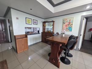 a living room with a wooden table and chairs at Robinsons Place Residences Tower 1 in Sampong