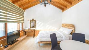 En eller flere senge i et værelse på Gangneung Sinami68 Pension