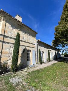 een oud stenen gebouw met bomen ervoor bij La maison de l'Architecte - Gite proche Bordeaux in Salleboeuf +13 foto's