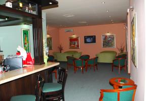 a waiting room with green chairs and a bar at Hotel Velbazhd in Kyustendil