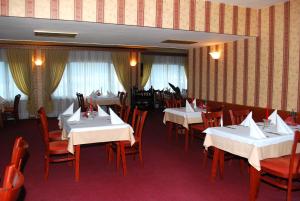 a dining room with white tables and red chairs at Hotel Velbazhd in Kyustendil